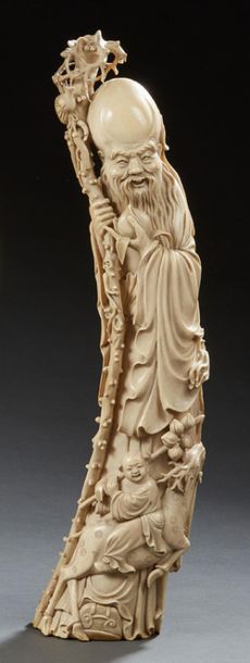 CHINE Importante défense en ivoire sculptée figurant un vieillard tenant sa canne...
