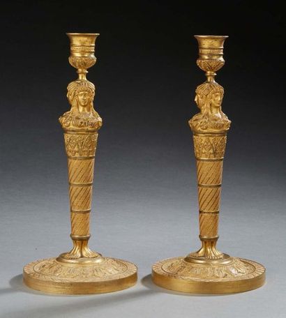 null PAIRE DE BOUGEOIRS en bronze doré orné de trois cariatides supportant une urne....