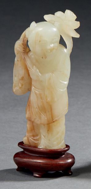 CHINE - XIXe siècle Petite statuette d'enfant debout en néphrite céladon, tenant...