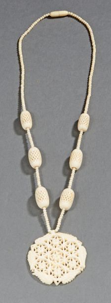 CHINE - Canton, vers 1900. Collier en ivoire en perle et médaillon ajouré à motif...