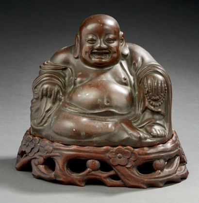 CHINE - XXe siècle Statuette de Budai en bronze à patine brune, assis contre son...