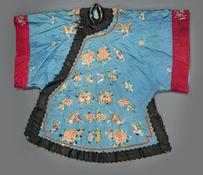 CHINE - XIXe siècle Veste de femme fermée sur le côté en soie bleue, brodées aux...