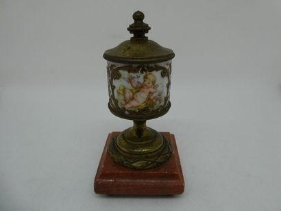 null Petite urne en porcelaine blanche à décor polychrome d'un putti et d'un bouquet...