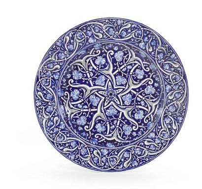 BOCH Frères Grand plat circulaire en faience à motifs moyen orientaux sur fond bleu....