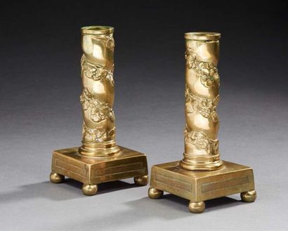 null Pair of brass candlesticks with a column motif on four ball feet. 
19th century
Size:...