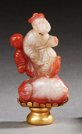 CHINE XXe siècle Bouchon en cornaline sculptée, personnages sur un grand poisson.
H....