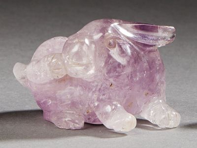 CHINE XXe siècle Small amethyst rabbit, scratching with its hind leg.
L.: 6 cm.
