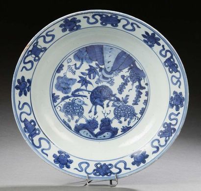 CHINE * Porcelain dish decorated in blue with rams and Buddhist objects.
Diam.: 30.4...