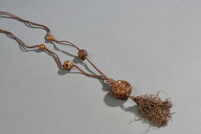 CHINE Silk pendant with balls of carved hard stone and brown openwork (jadeite?)....