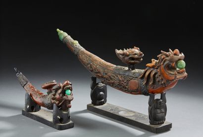 CHINE Set of two carved wooden opium pipes with chimeras holding green stones.
Size:...
