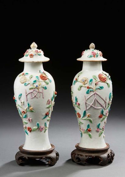 CHINE Pair of small covered porcelain baluster-shaped vases, decorated in light relief...