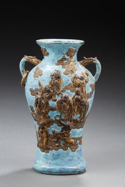CHINE Vase à anses de forme balustre en porcelaine à fond et décoré en relief doré...