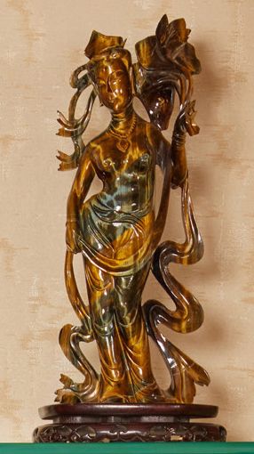CHINE - XXe siècle Statuette de femme debout en oeil du tigre tenant une branche...