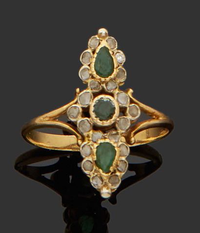 null NAVETTE RING in 18K (750) yellow gold set with three emeralds surrounded by...