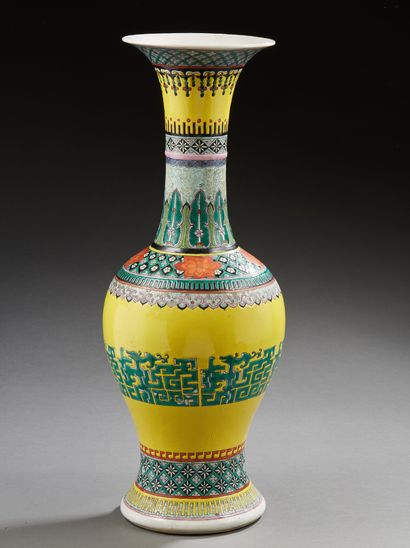CHINE A baluster-shaped porcelain vase with a yellow background decorated in green...