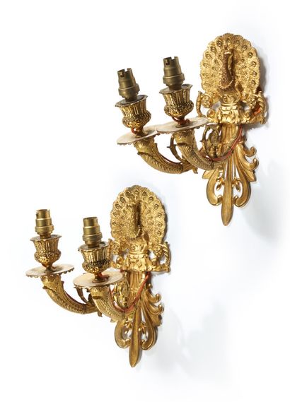 null A PAIR OF TWO LIGHTINGS in chased and gilt bronze; the plate showing a peacock...