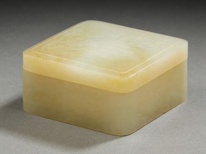 CHINE A small square covered box made of light green carved jade. The lid with a...