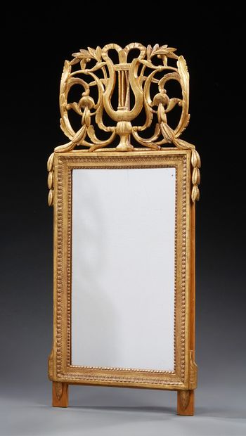 null MIROIR en bois sculpté et doré à fronton ajouré d'une lyre.
Style Louis XVI.
H....