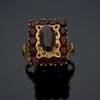 null RING in yellow gold 750 mm rectangular, set with an oval garnet in a circle...