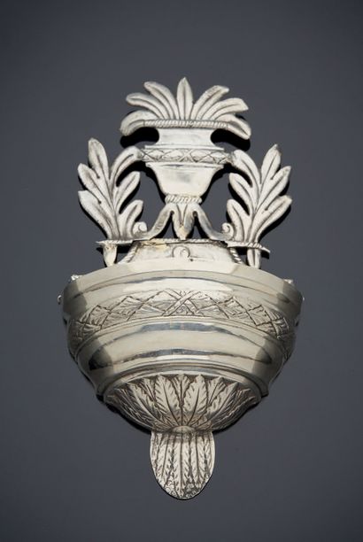 null A silver embossed APPLIQUE BENITIER with foliage and flowering urn decoration.
Foreign...