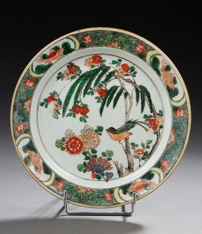 CHINE A circular porcelain plate decorated in green family enamels with a bird in...