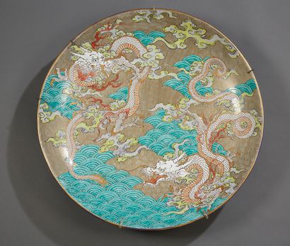 JAPON Grand plat en porcelaine émaillé à motif de dragons dans des nuages.
Vers 1900.
Diam....