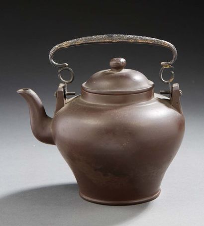 CHINE A Yixing brown stoneware teapot with a mark on the reverse, the metal handle
Second...