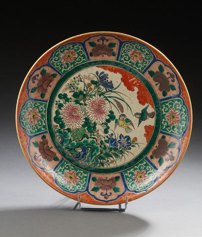 JAPON (Kutani) * Plat circulaire en porcelaine à décor polychrome d'hirondelles avec...