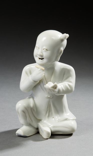 CHINE Figurine en porcelaine émaillée blanche représentant un enfant (hoho) assis...