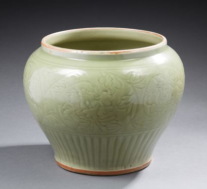 CHINE A large celadon-glazed porcelain guan jar with incised lotus flower decoration...