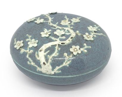CHINE Circular covered porcelain box with relief decoration on the lid of prunus...