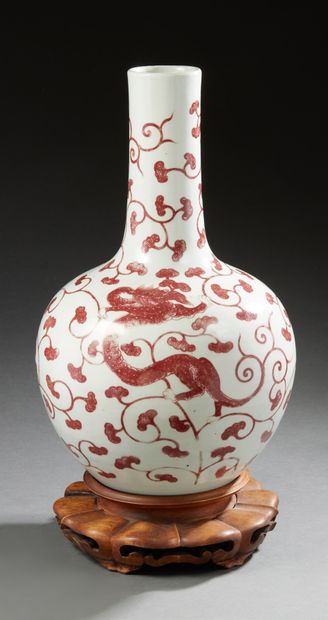 CHINE A long narrow-necked porcelain bottle vase decorated in copper red with three...
