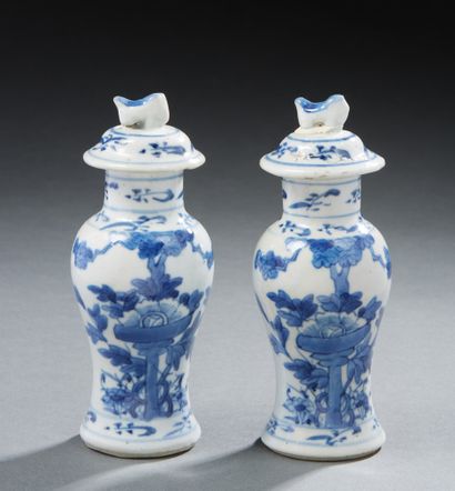 CHINE A pair of small covered porcelain vases decorated in blue with flowers. On...