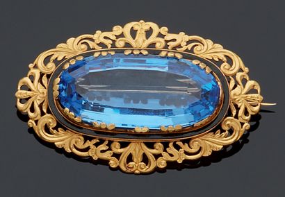 null A yellow gold 750 mm pin set with an oblong imitation blue stone on a black...