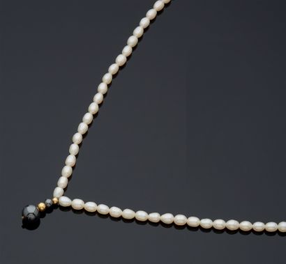 null NECKLACE composed of a row of freshwater pearls, supporting a pattern of small...