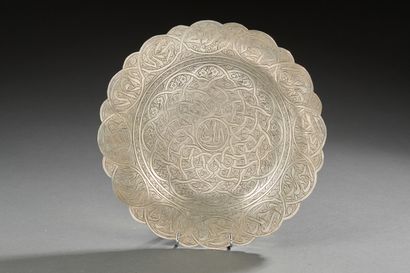 null Small circular plate with scrolled edges in silver engraved with rinceaux.

Egyptian...
