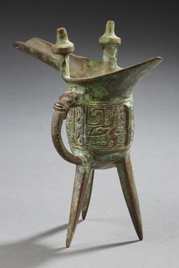 CHINE A bronze tripod cup. The body with characters.
Archaic style.
H. : 18 cm