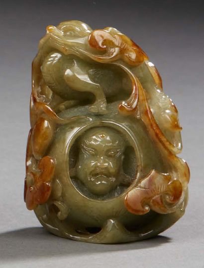 CHINE Green nephrite group carved with a head of a deity with a trace of rust.
Dim....