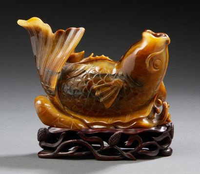 CHINE Figurine representing a reclining carp framed by water lilies carved in tiger's...