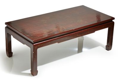 CHINE Table basse en bois laqué rouge à motif de volatiles dorés.
Vers 1900. .