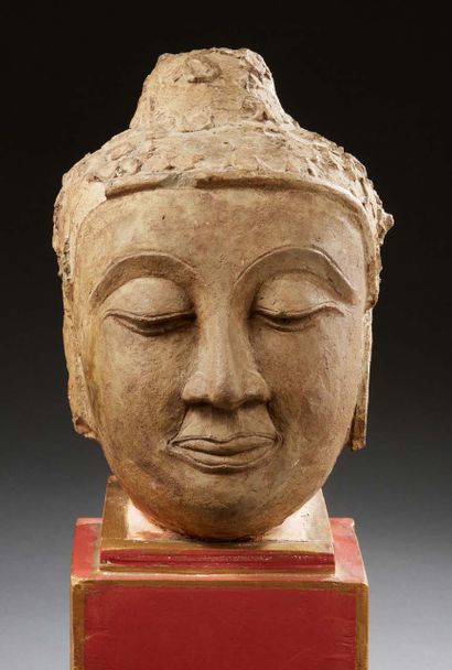 ASIE DU SUD EST Important head of a divinity in carved stone. On a red wood base.
H....
