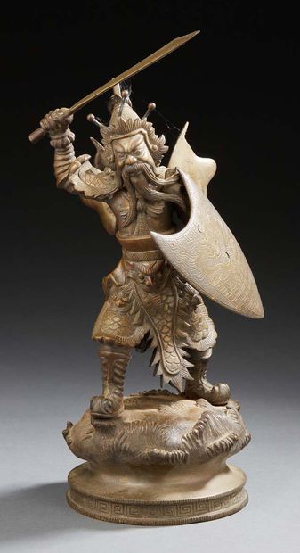 CHINE Bronze figurine representing a warrior standing on a mound brandishing a sword,...
