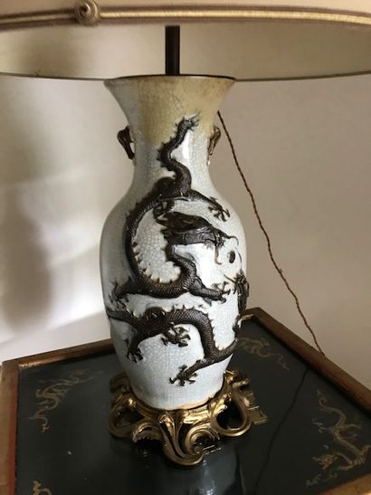 null Grande lampe en porcelaine craquelée à décor d'un dragon en relief.

Monture...