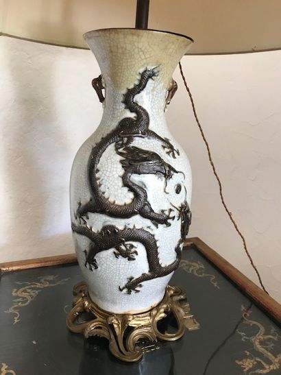 null Grande lampe en porcelaine craquelée à décor d'un dragon en relief.

Monture...
