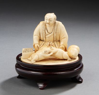 JAPON Okimono en ivoire sculpté figurant un homme et deux grenouilles.
Signé au revers.
Vers...