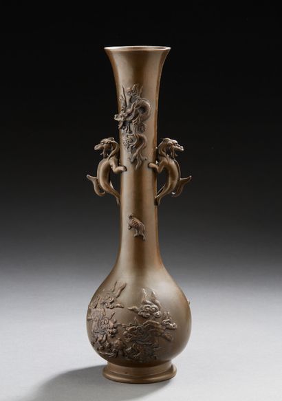 JAPON Vase à long col étroit en bronze décoré en léger relief de lions bouddhiques...