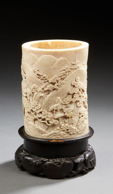 CHINE A finely carved ivory brush holder with a motif of animated scenes in mountainous...