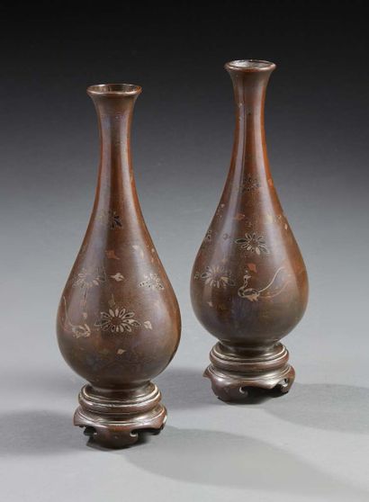 CHINE Paire de vases à long col en bronze à patine brune à décor de fleurs polychromes.
Période...