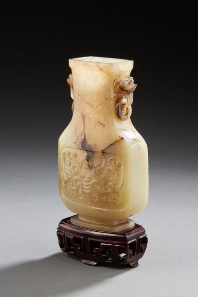 CHINE A light grey jade vase carved with traces of rust in brown with motifs on both...