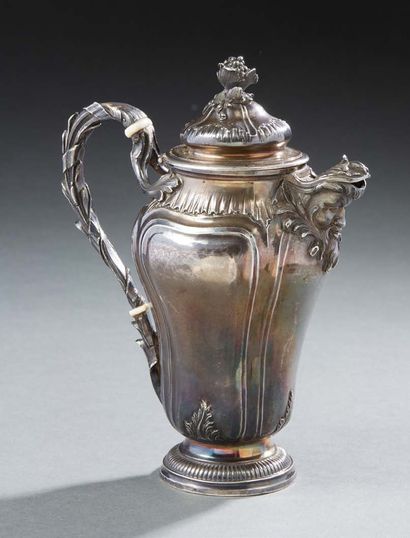 null A silver egoistic coffee pot with a rocky motif, standing on a pedestal. The...